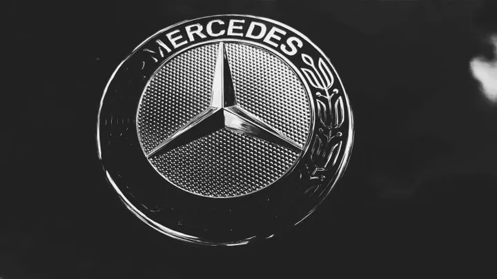 Sigla Mercedes-Benz pe un fundal întunecat, simbol al inovației și calității.