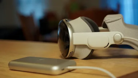 Cască Apple Vision Pro pe o masă, cu un cablu conectat.