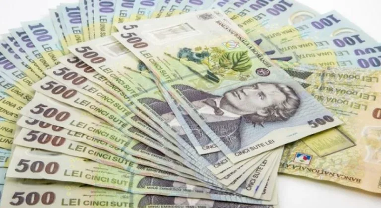Bancnote românești cu diverse valori, inclusiv 500 lei, aranjate pe o suprafață.