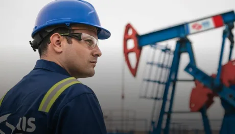 Un angajat al unei companii petroliere observând echipamentele de extracție.