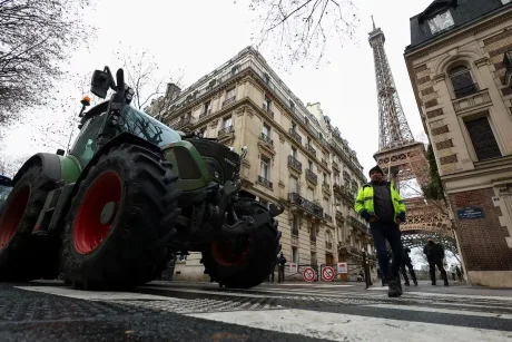 Tractor pe stradă, cu Turnul Eiffel în fundal, protest agricol.