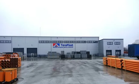 Clădire TeraPlast cu materiale de construcție pe platformă.