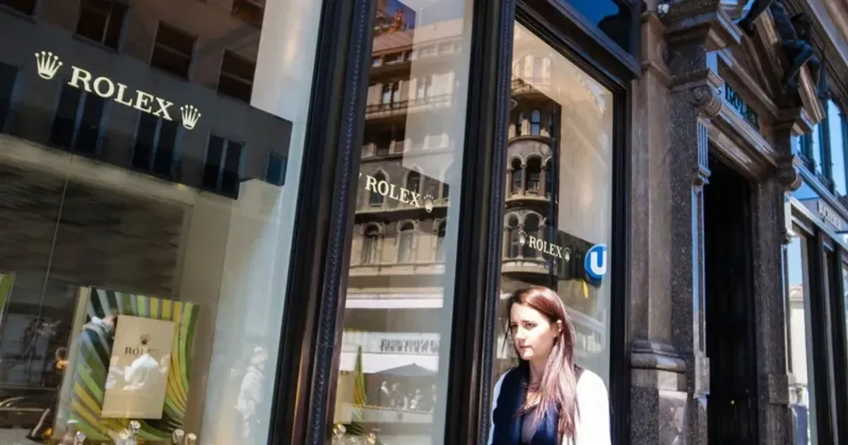 O femeie trece pe lângă un magazin Rolex din Elveția.