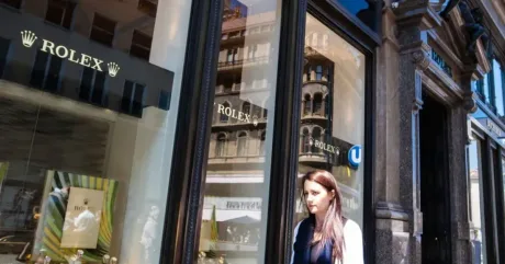 O femeie trece pe lângă un magazin Rolex din Elveția.