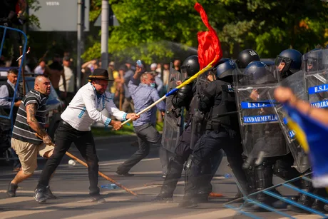 Protest violent în Piața Victoriei, cu participanți și forțe de ordine în confruntare.