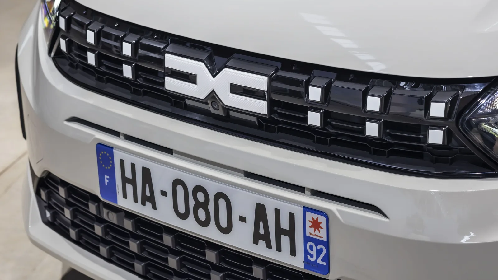 Grila frontală a unui model Dacia Sandero hibrid.