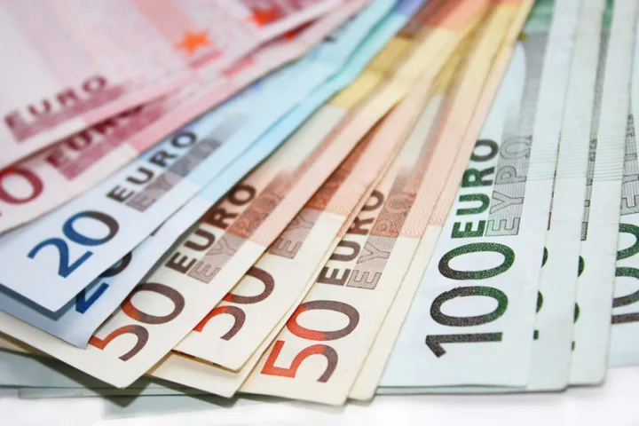 Bancnote euro aranjate pe o suprafață plană, diverse valori vizibile.