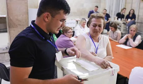 Oameni votând la alegerile parlamentare din Armenia, într-un mediu organizat.