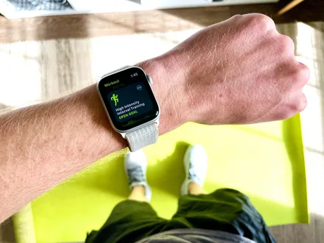Brățară inteligentă pe încheietura mâinii, cu Apple Watch activat.