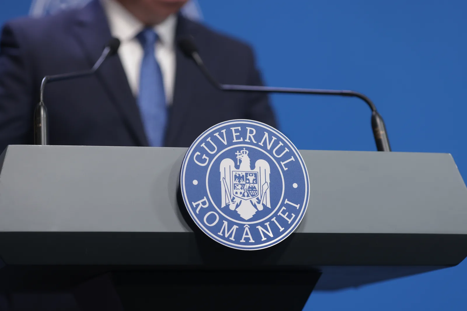 Sigla Guvernului României pe un fundal albastru.
