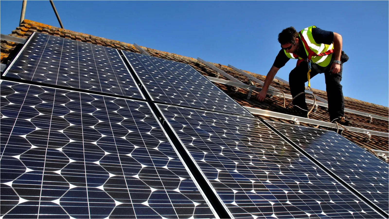 Instalare panouri solare pe acoperiș, simbol al energiei regenerabile.