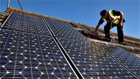 Instalare panouri solare pe acoperiș, simbol al energiei regenerabile.