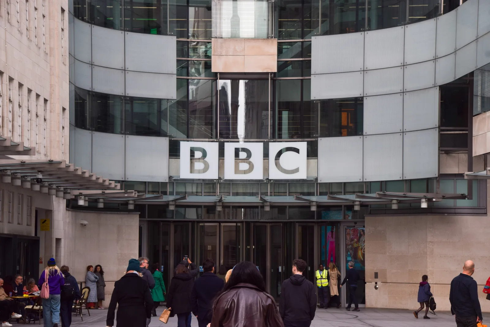 Clădirea BBC, un simbol al jurnalismului britanic, cu oameni în față.
