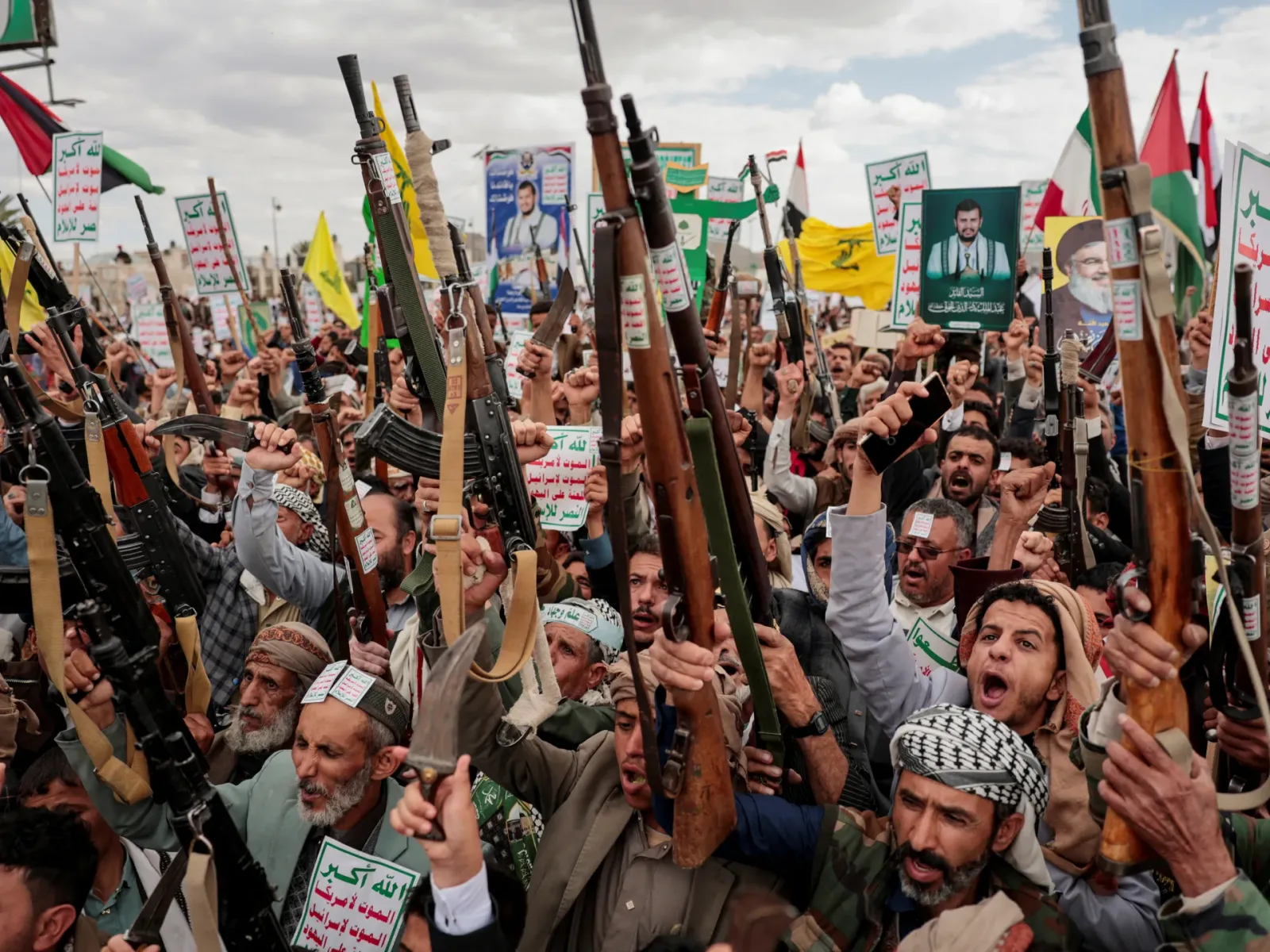 Protest al rebelilor Houthi în Yemen, cu pancarte și arme în mână.