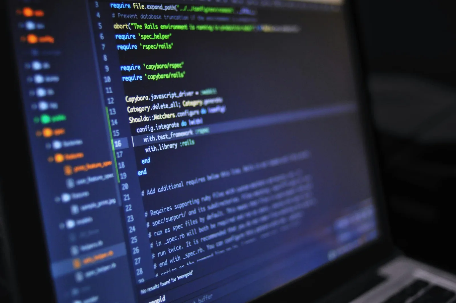 Ecran de laptop cu cod sursă și linii de programare vizibile.