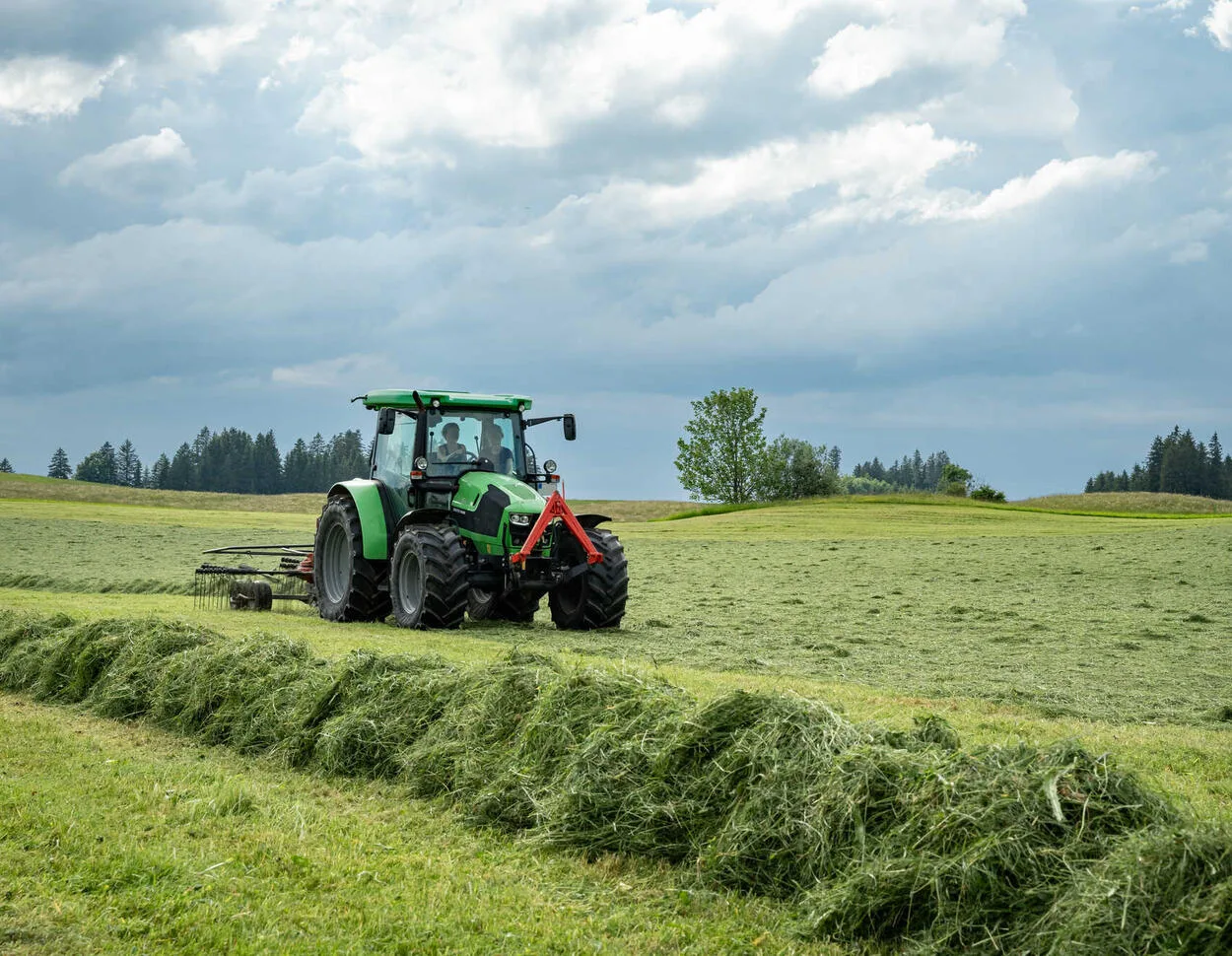 Tractor pe câmp, cosind fân în Bavaria, pe fondul secetei.