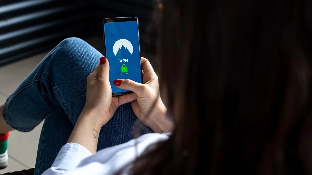 Utilizator conectat la un VPN pe telefonul mobil, relaxându-se acasă.