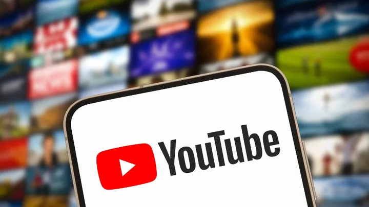 Logo YouTube pe un telefon, înconjurat de conținut video divers.