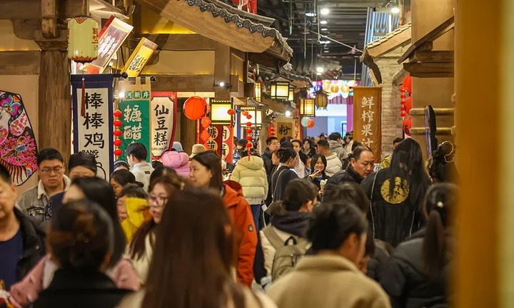 Stradă aglomerată cu oameni și magazine tradiționale din China.