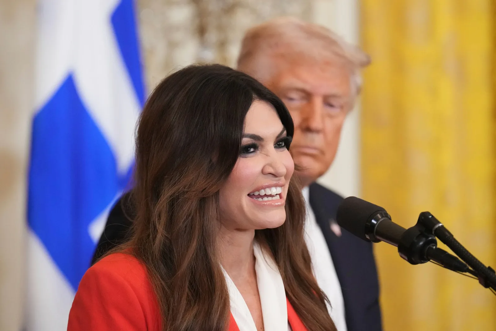 Donald Trump și Kimberly Guilfoyle la o conferință de presă, discutând despre relațiile diplomatice.