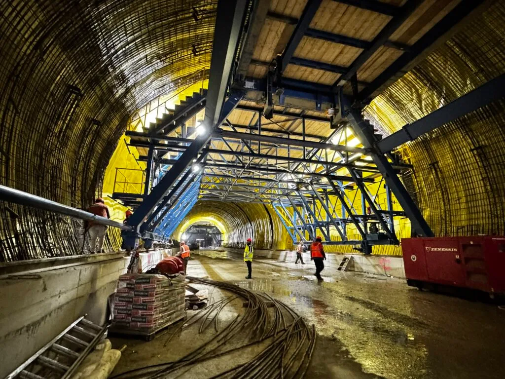 Lucrări avansate la tunelul Margina-Holdea, cu muncitori și utilaje pe șantier.