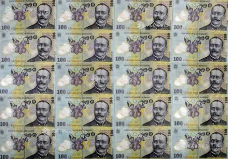 Bancnote românești de 100 lei aranjate pe o suprafață plană.