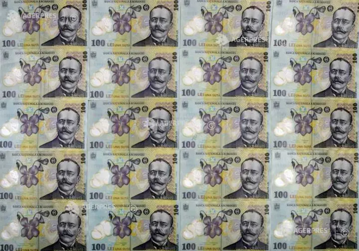 Bancnote românești de 100 lei aranjate pe o suprafață plană.