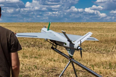 Drone pe câmp, pregătite pentru zbor în context militar.
