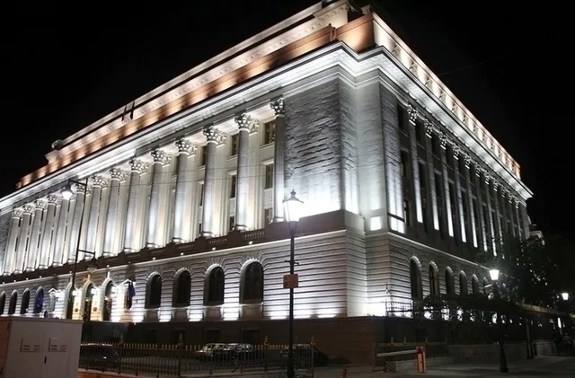 Clădirea BNR iluminată noaptea, simbol al stabilității financiare.