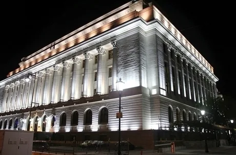 Clădirea BNR iluminată noaptea, simbol al stabilității financiare.