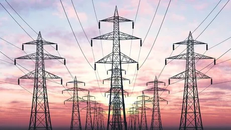 Linii electrice la apus, simbolizând consumul de energie.