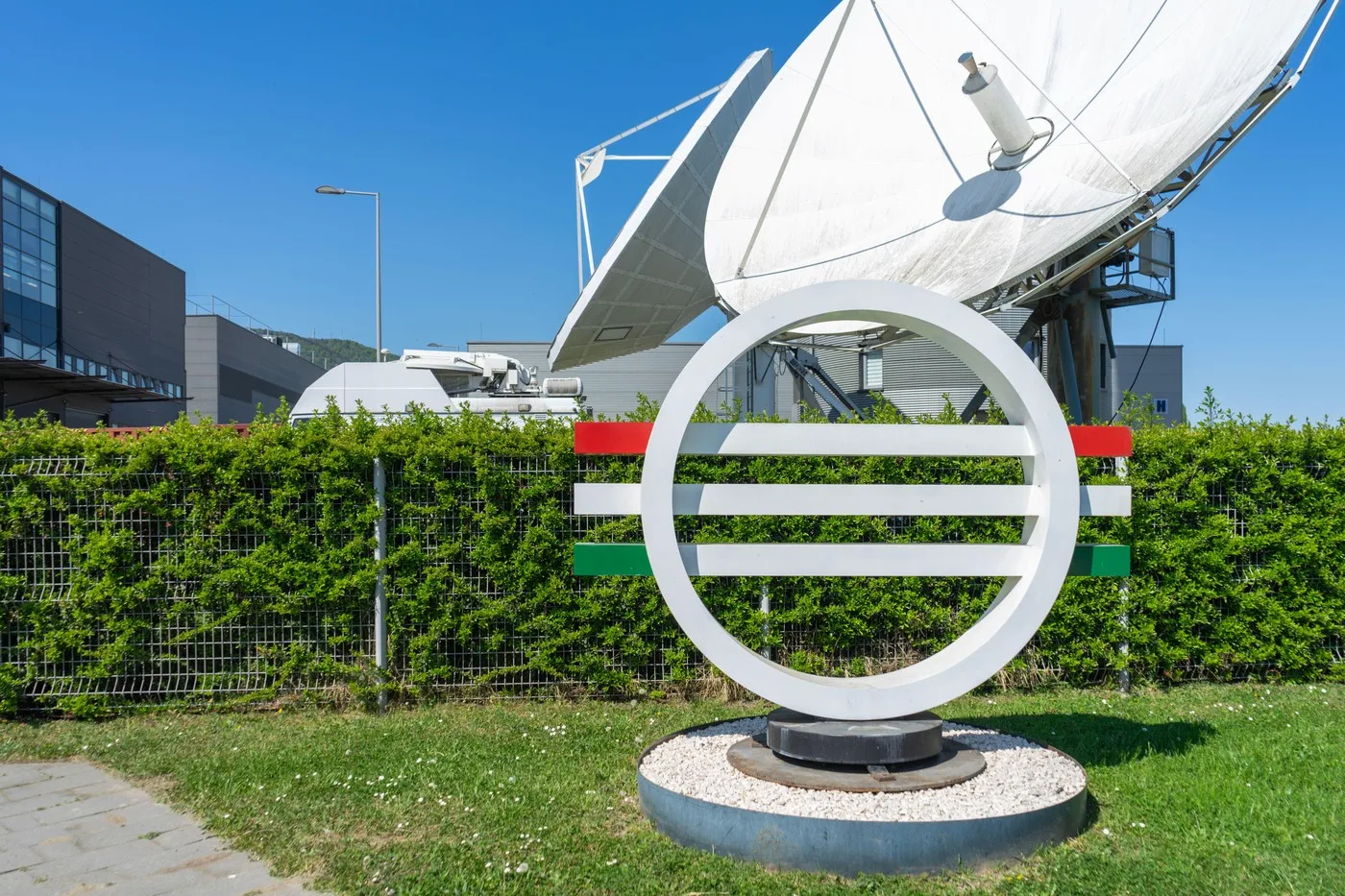 Logo-ul televiziunii publice din Ungaria, cu antene satelit în fundal.