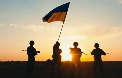 Soldați ucraineni cu steagul național la apus.